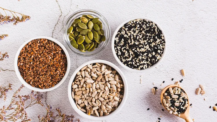 Schälchen mit verschiedenen Samen und Kernen auf einem hellen Untergrund.