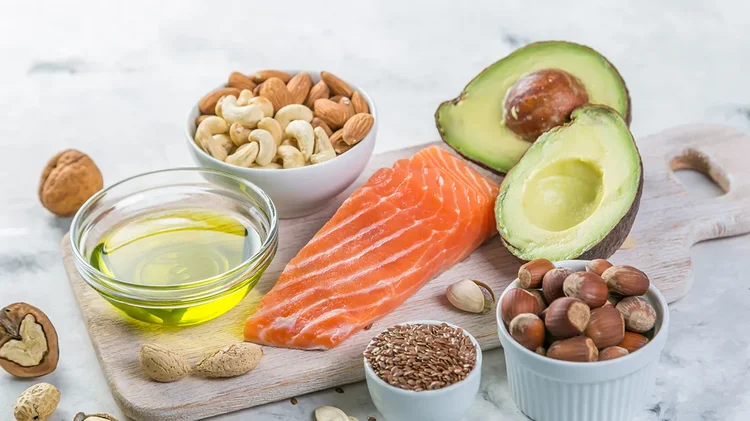 Lachs, Avocado, Nüsse und Olivenöl als Quellen gesunder Fette.