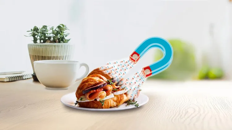 Croissant auf Teller mit Magnetgrafik darüber.