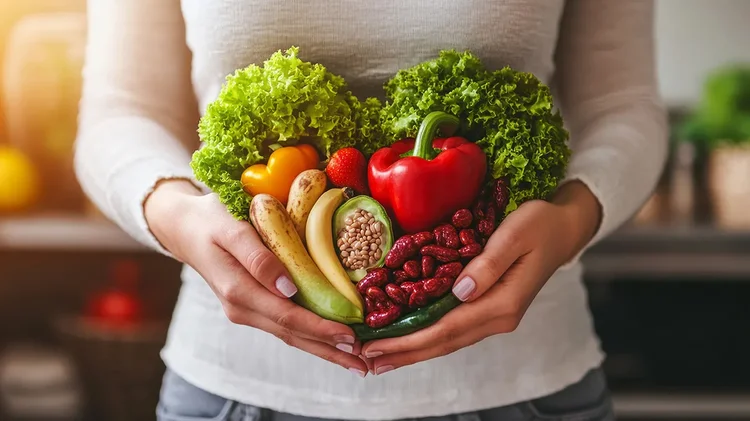 Obst und Gemüse wird von Händen einer Frau gehalten