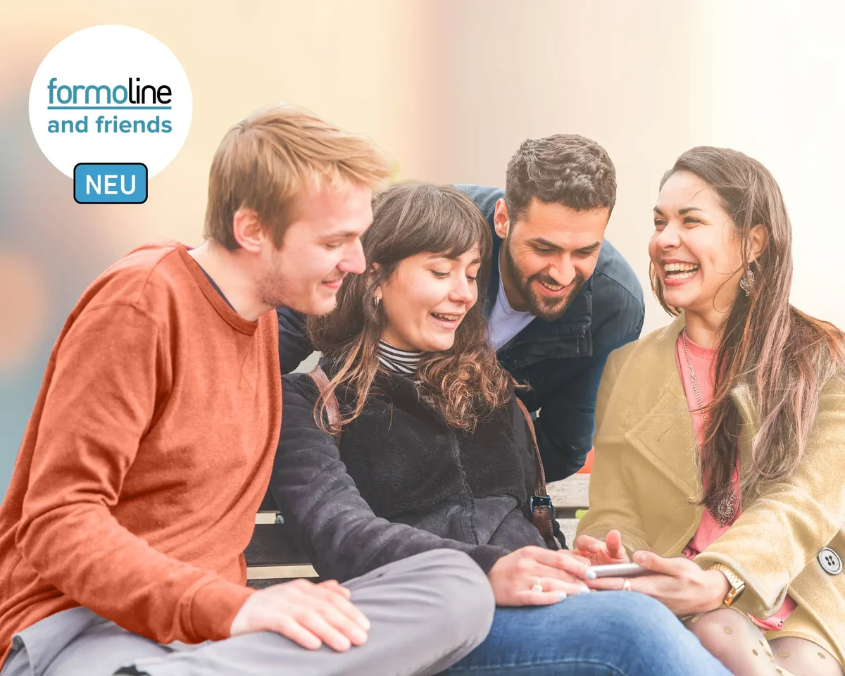 Vier Erwachsene sitzen gemeinsam im Freien und schauen lächelnd auf ein Tablet – formoline and friends