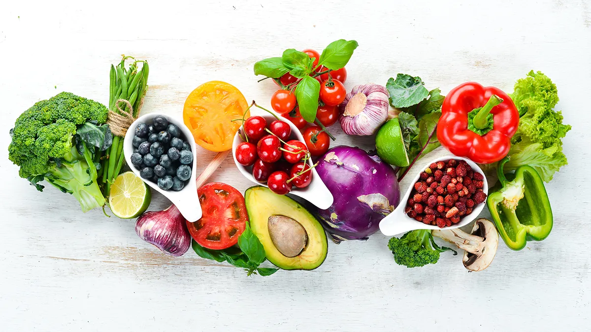 Verschiedenes frisches Obst und Gemüse auf weißem Tisch.