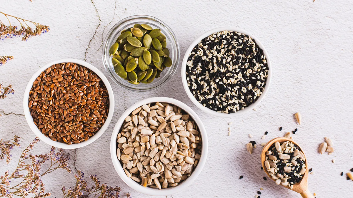 Schälchen mit verschiedenen Samen und Kernen auf einem hellen Untergrund.