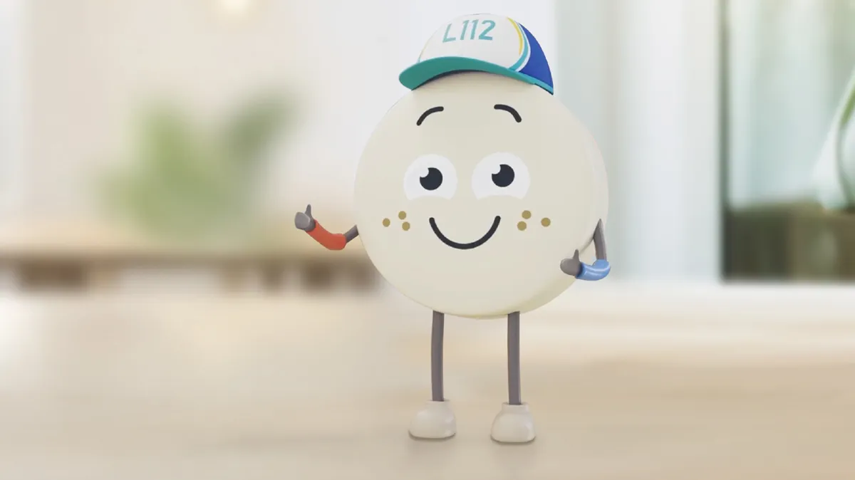 Runde Figur mit Mütze steht auf Tisch.