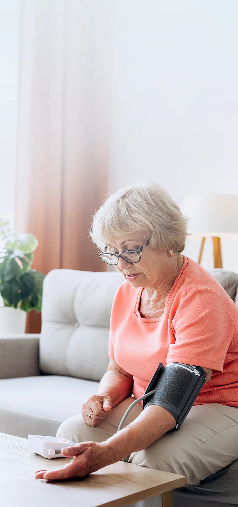 Ältere Frau misst zu Hause ihren Blutdruck mit digitalem Messgerät.Ältere Frau misst zu Hause ihren Blutdruck mit digitalem Messgerät.