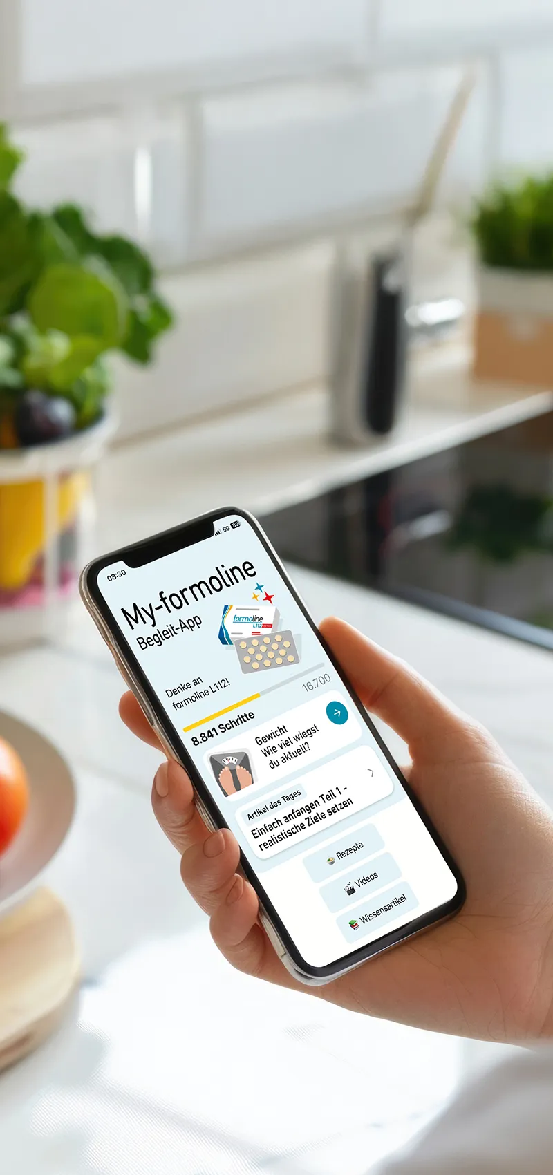 Smartphone mit My-formoline App neben frischem Gemüse in Küche.