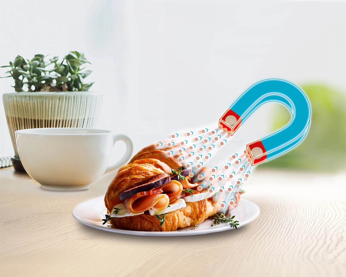 Illustration zeigt Magnet, der Fettmoleküle aus einem Croissant zieht.