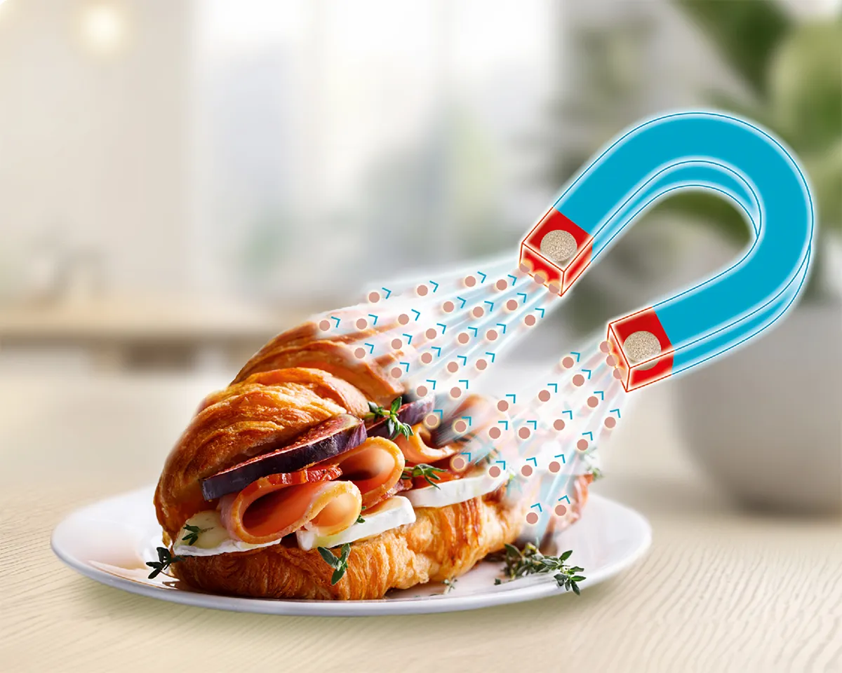 Magnet zieht Fettpartikel von einem Croissant an – Darstellung der Fettbindung.