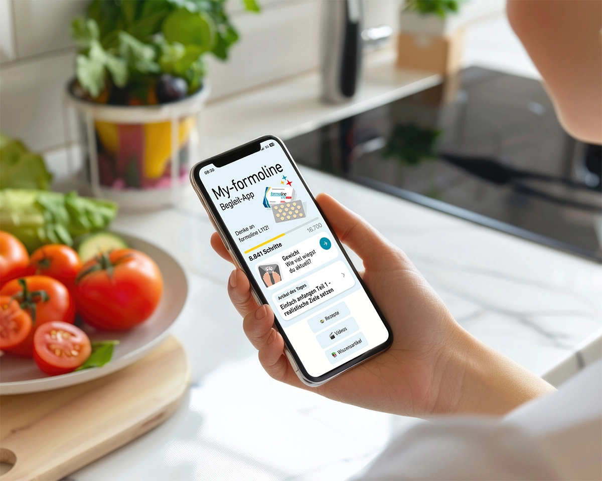 Smartphone mit geöffneter My-formoline App in Küche mit Gemüse.