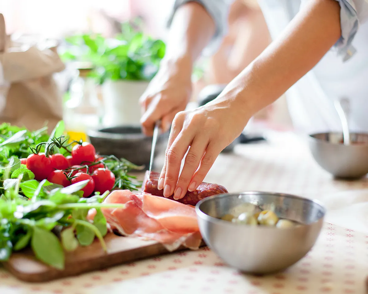 Frisches Gemüse und Fisch werden auf einem Küchentisch zubereitet.