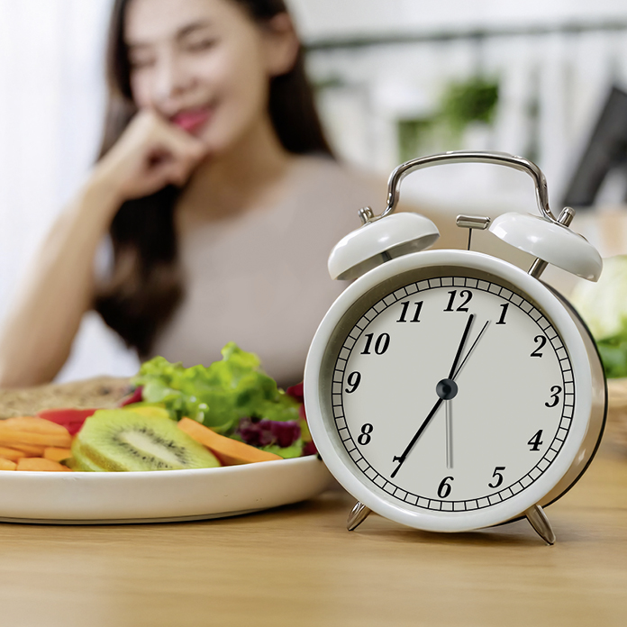 Wecker und gesunde Mahlzeit  Intervallfasten Symbolbild mit Wecker und gesunder Mahlzeit