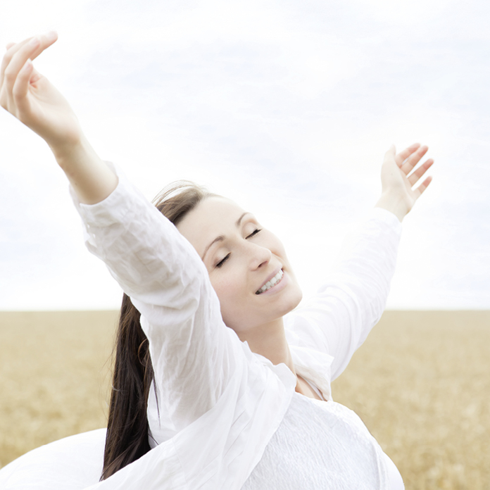 Frau mit ausgebreiteten Armen im Freien – Symbol für Leichtigkeit und Wohlbefinden durch Intervallfasten 5:2